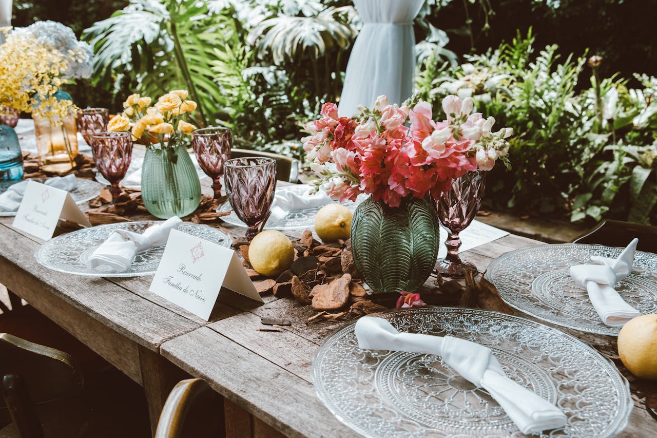 Beautiful outdoor dining setup with elegant floral arrangements and decorative glassware.